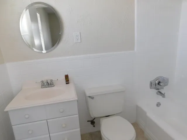 a bathroom with a sink mirror and toilet