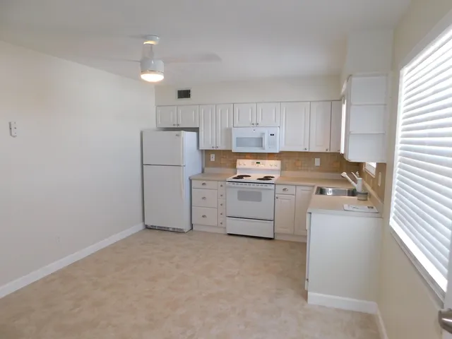 a kitchen with cabinets a sink and white stainless steel appliances