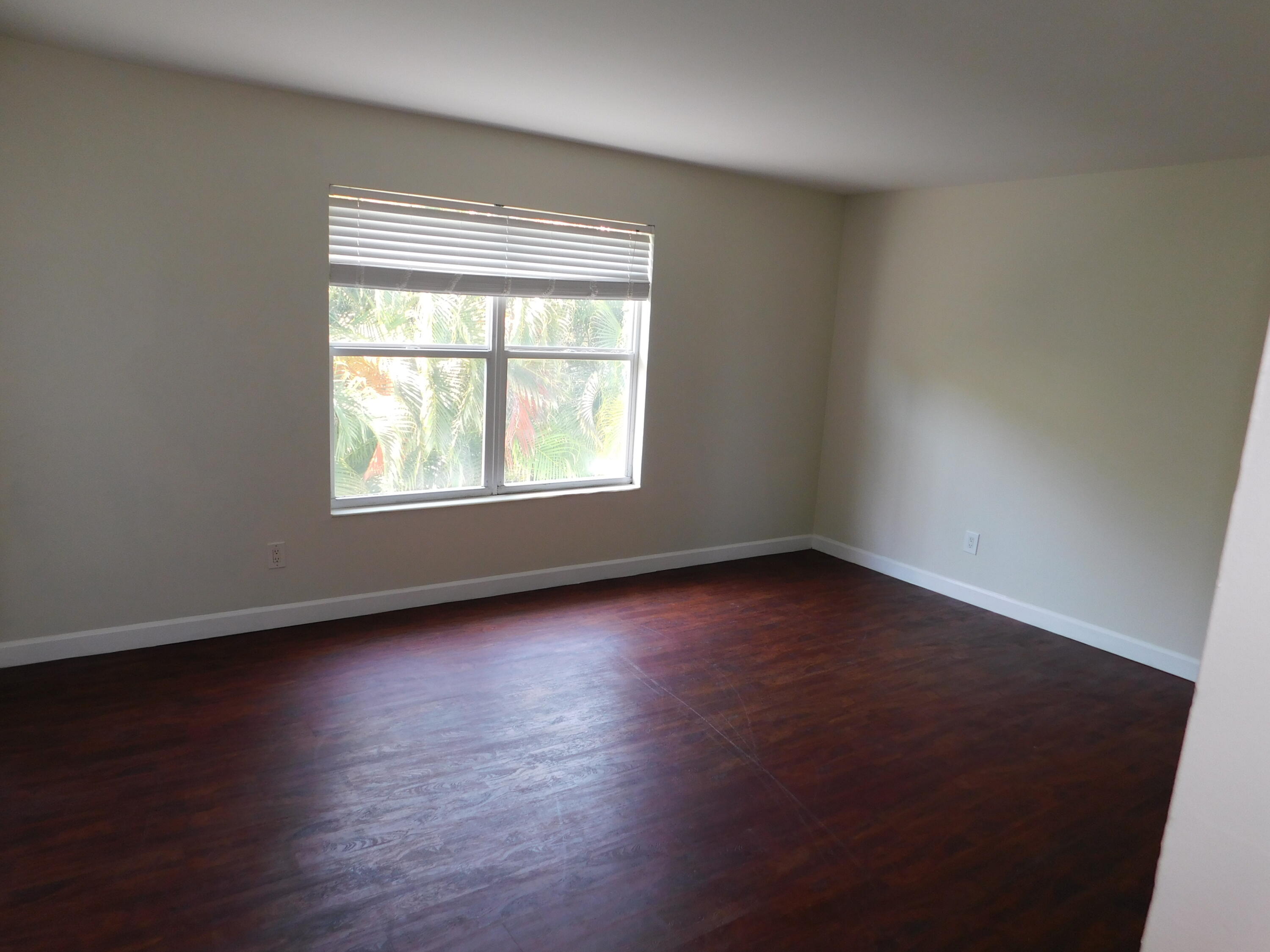 741 Hummingbird Way, Unit 4 North Palm Beach, FL 33408 - Photo 5 of 19 an empty room with wooden floor and windows