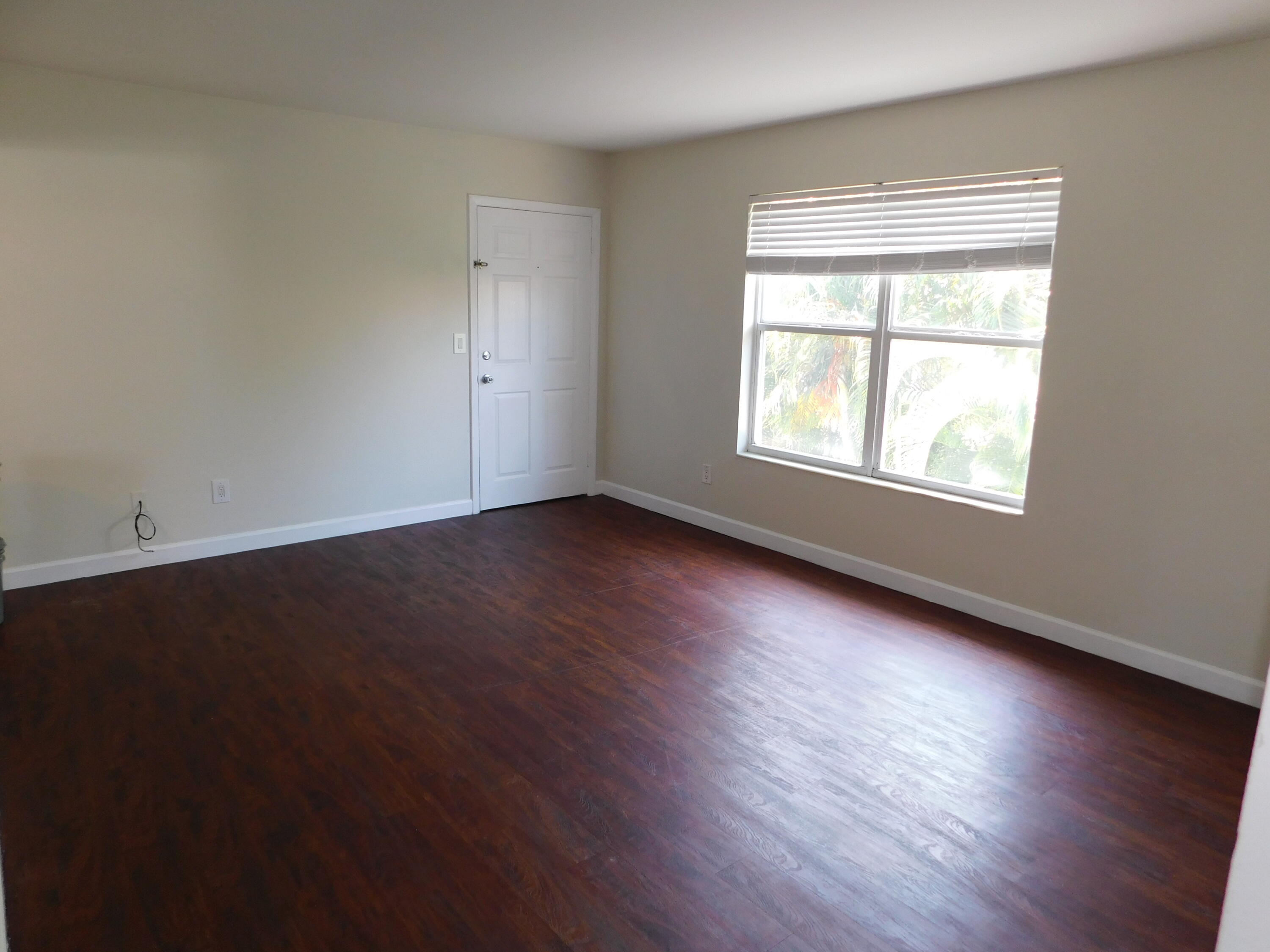 741 Hummingbird Way, Unit 4 North Palm Beach, FL 33408 - Photo 6 of 19 an empty room with wooden floor and windows