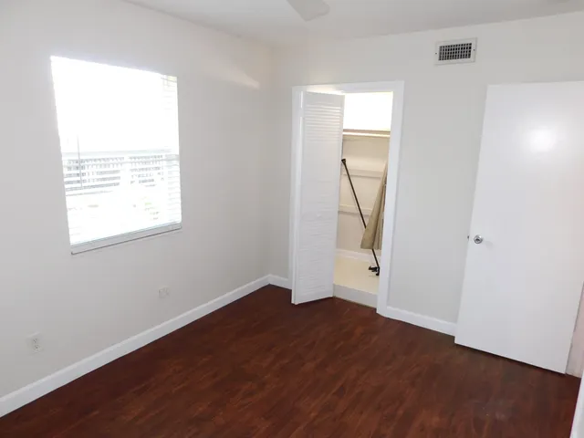 an empty room with wooden floor and a window