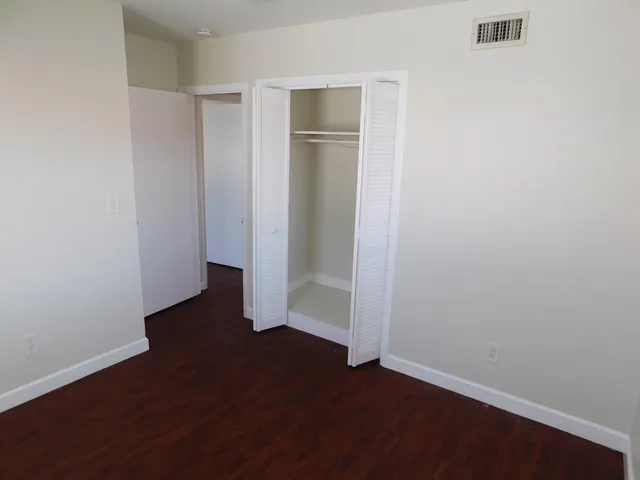 an empty room with wooden floor and closet