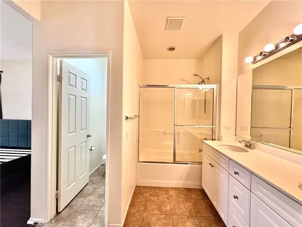a large white bathroom with a granite countertop sink and a large mirror
