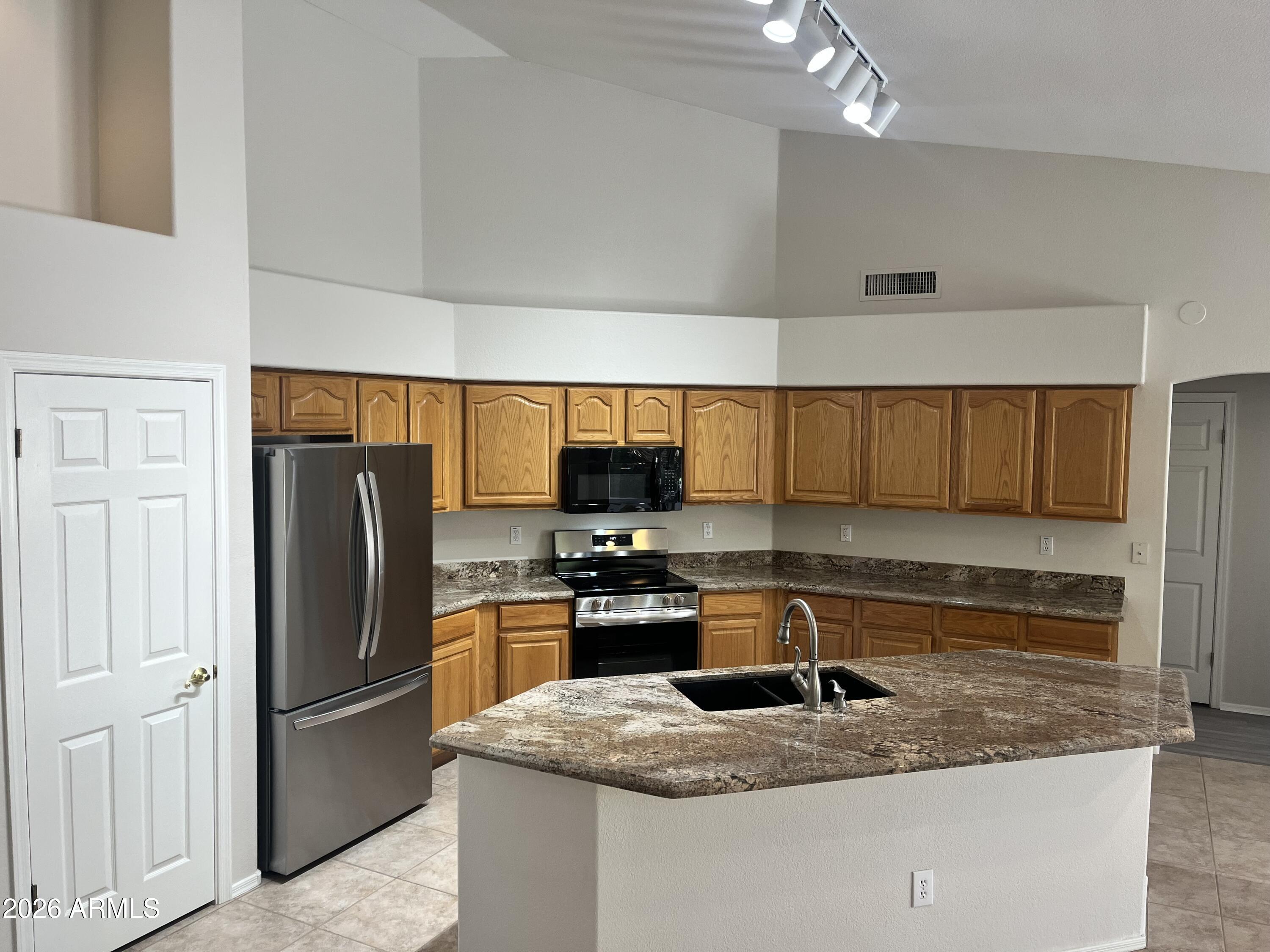 1182 East Harrison Street Gilbert, AZ 85295 - Photo 3 of 21 a kitchen with refrigerator and cabinets