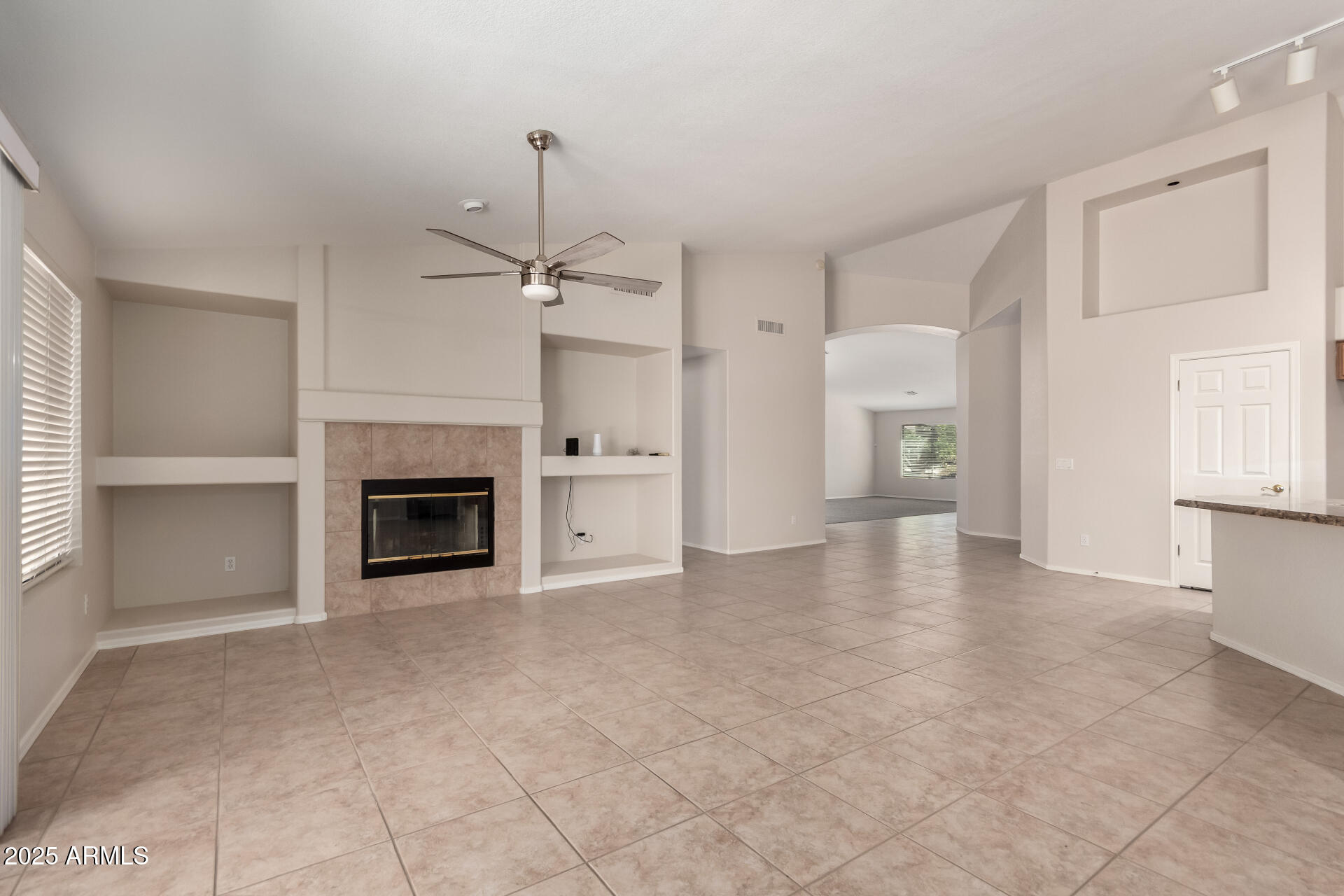1182 East Harrison Street Gilbert, AZ 85295 - Photo 8 of 21 a view of an empty room with a fireplace and a window