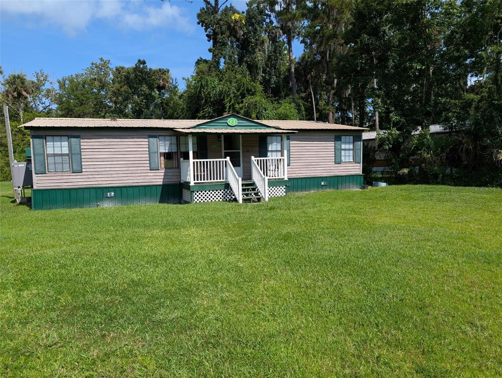 a view of a house with a yard and tree