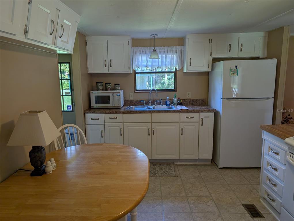 56314 Blue Creek Road Astor, FL 32102 - Photo 11 of 23 a kitchen with kitchen island a sink a stove and refrigerator