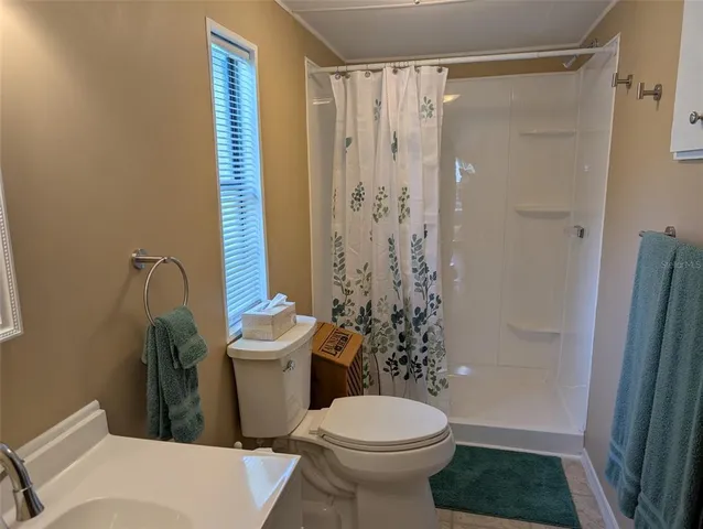a bathroom with a shower a toilet and a sink