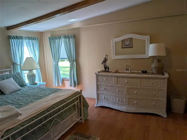 a bedroom with a bed and large windows