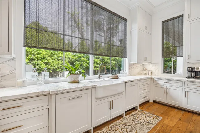 a white kitchen with a sink and large window