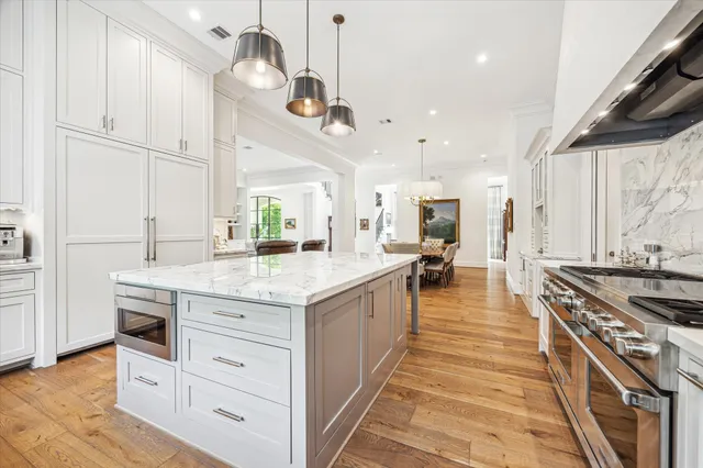 a kitchen with stainless steel appliances granite countertop a stove and a wooden floors