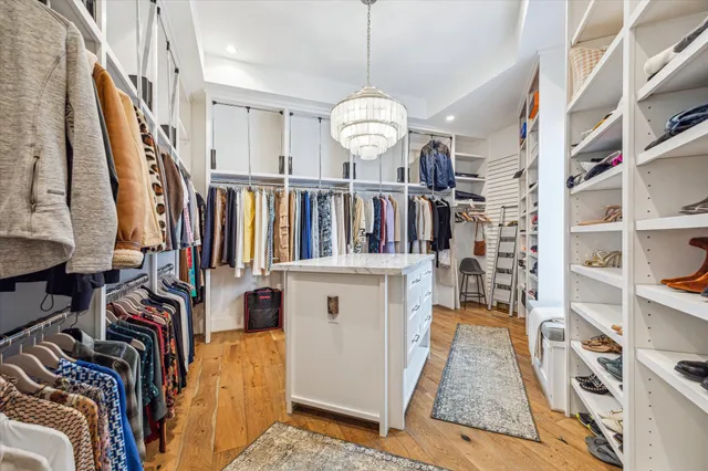 a bedroom with a bed chandelier and a window