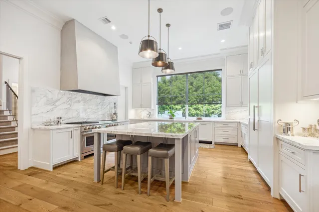 a kitchen with kitchen island granite countertop a table chairs sink and cabinets