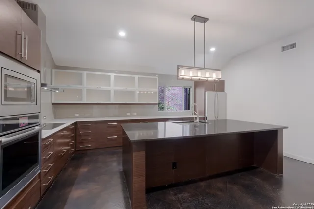 a kitchen with kitchen island a sink stainless steel appliances and cabinets