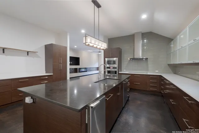 a kitchen with stainless steel appliances granite countertop a sink a stove and a refrigerator