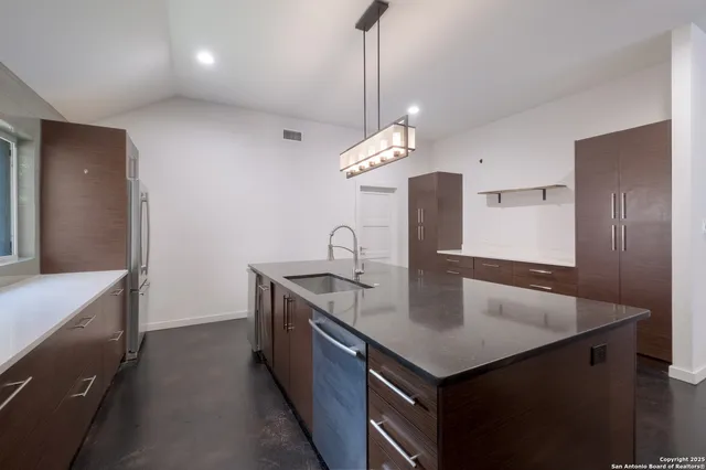 a kitchen with stainless steel appliances granite countertop a sink a counter space and cabinets