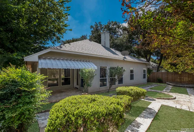 a view of a house with backyard and sitting area