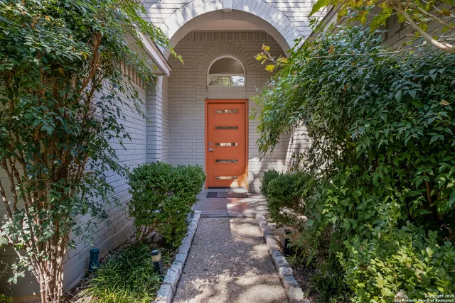 a front view of a house with a yard and green space