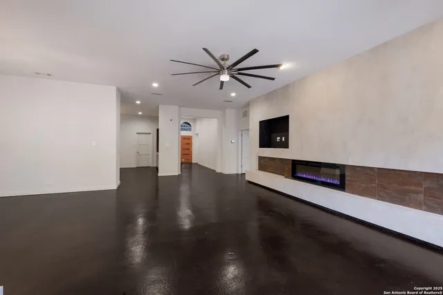 a view of a room with wooden floor and a ceiling fan