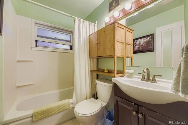 a bathroom with a sink a mirror a toilet and shower