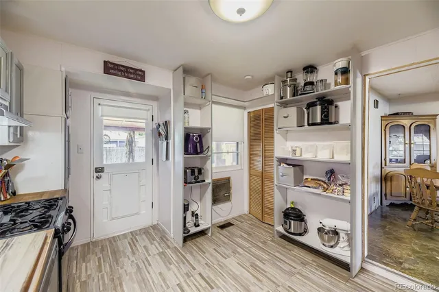 a view of a kitchen with fridge and wooden floor