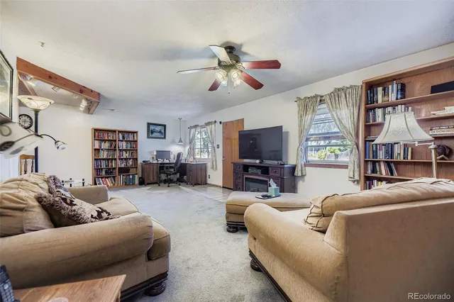 a living room with furniture a ceiling fan and a window