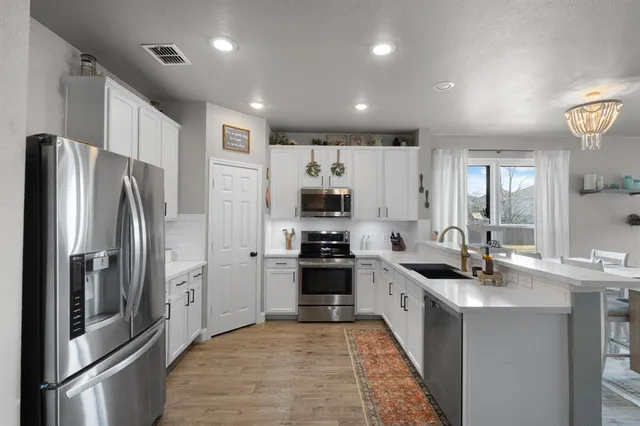 a kitchen with stainless steel appliances granite countertop a refrigerator and a sink