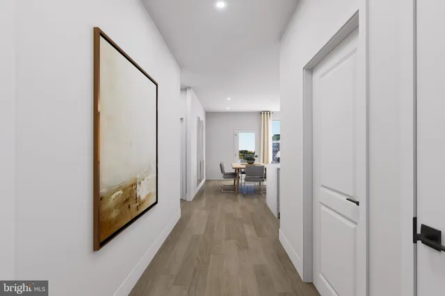 a view of a hallway with a wooden floor and a bathroom