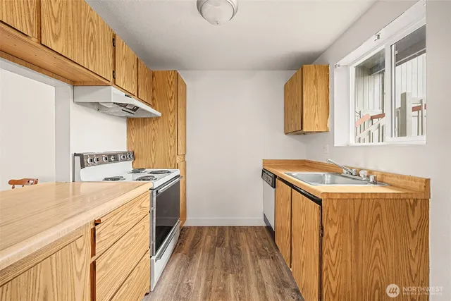 a utility room with wooden floor washer and dryer