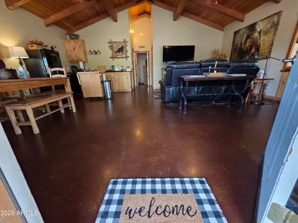a living room with furniture a rug kitchen view and a window