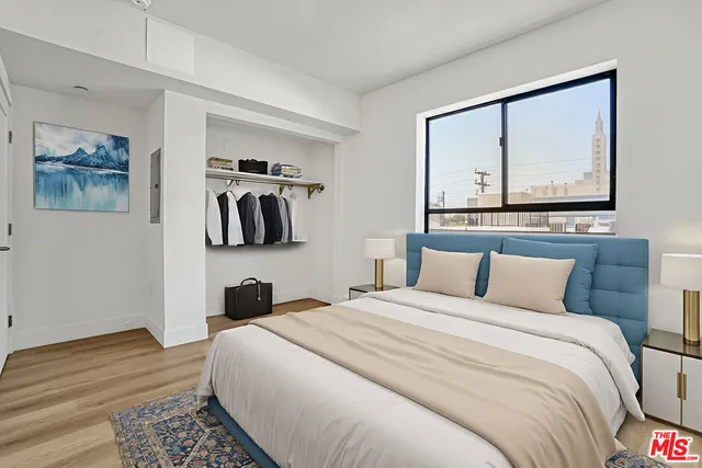 a bedroom with a bed and a painting on the wall