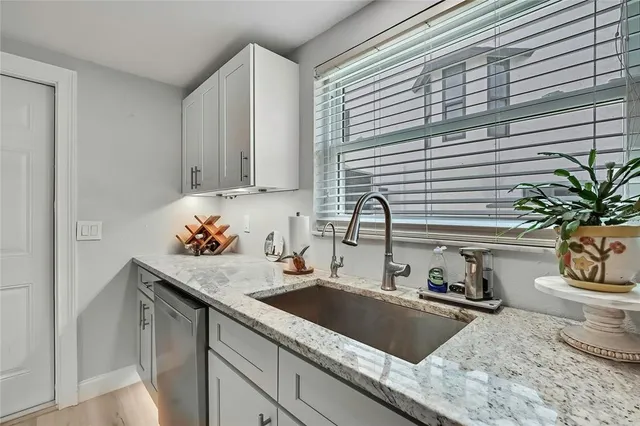 a kitchen with white cabinets stainless steel appliances and sink