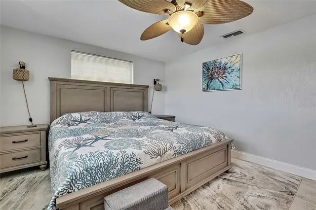 a bedroom with a bed and a flat tv screen on dresser