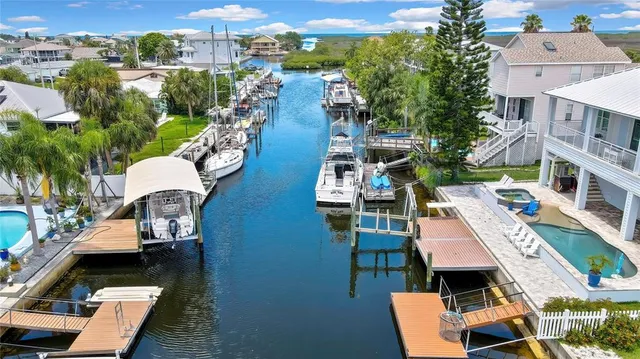 an aerial view of a house with swimming pool a patio and lake view