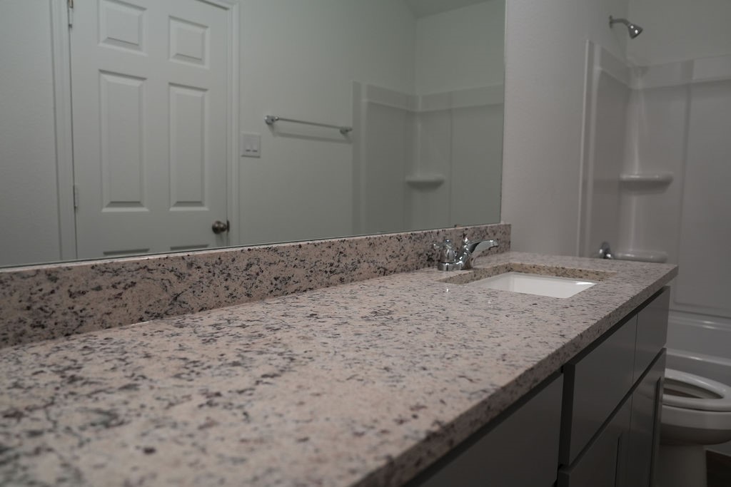 10465 Sugar Mill Drive Conroe, TX 77306 - Photo 21 of 29 a bathroom with a granite countertop sink and a granite