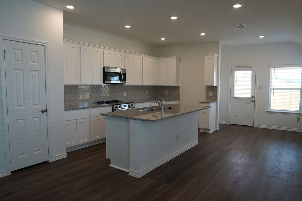 10465 Sugar Mill Drive Conroe, TX 77306 - Photo 3 of 29 a kitchen with sink cabinets and wooden floor