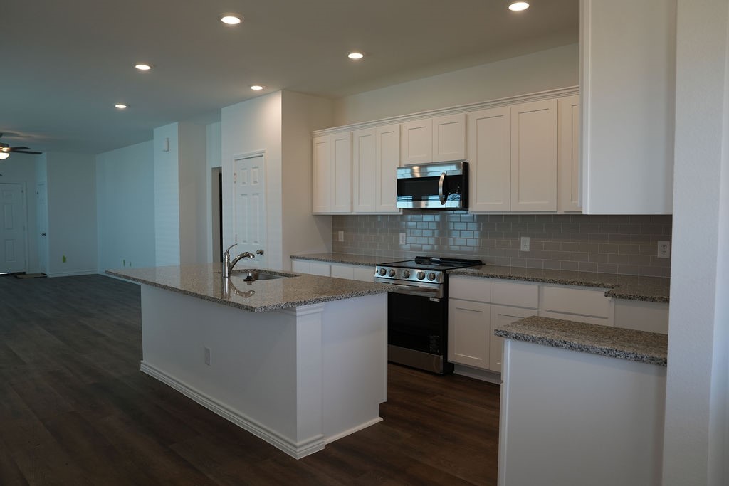 10465 Sugar Mill Drive Conroe, TX 77306 - Photo 4 of 29 a kitchen with stainless steel appliances granite countertop a sink stove and microwave