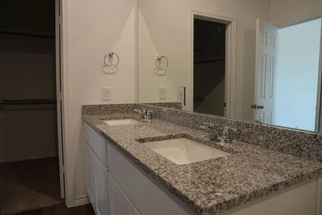 a bathroom with a granite countertop sink and a mirror