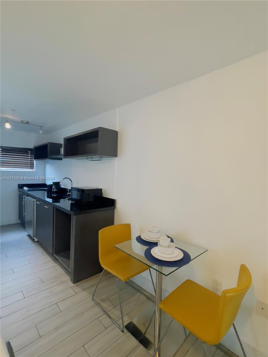 7500 Collins Avenue, Unit 114 Miami Beach, FL 33141 - Photo 3 of 9 a kitchen with a table and chairs in it