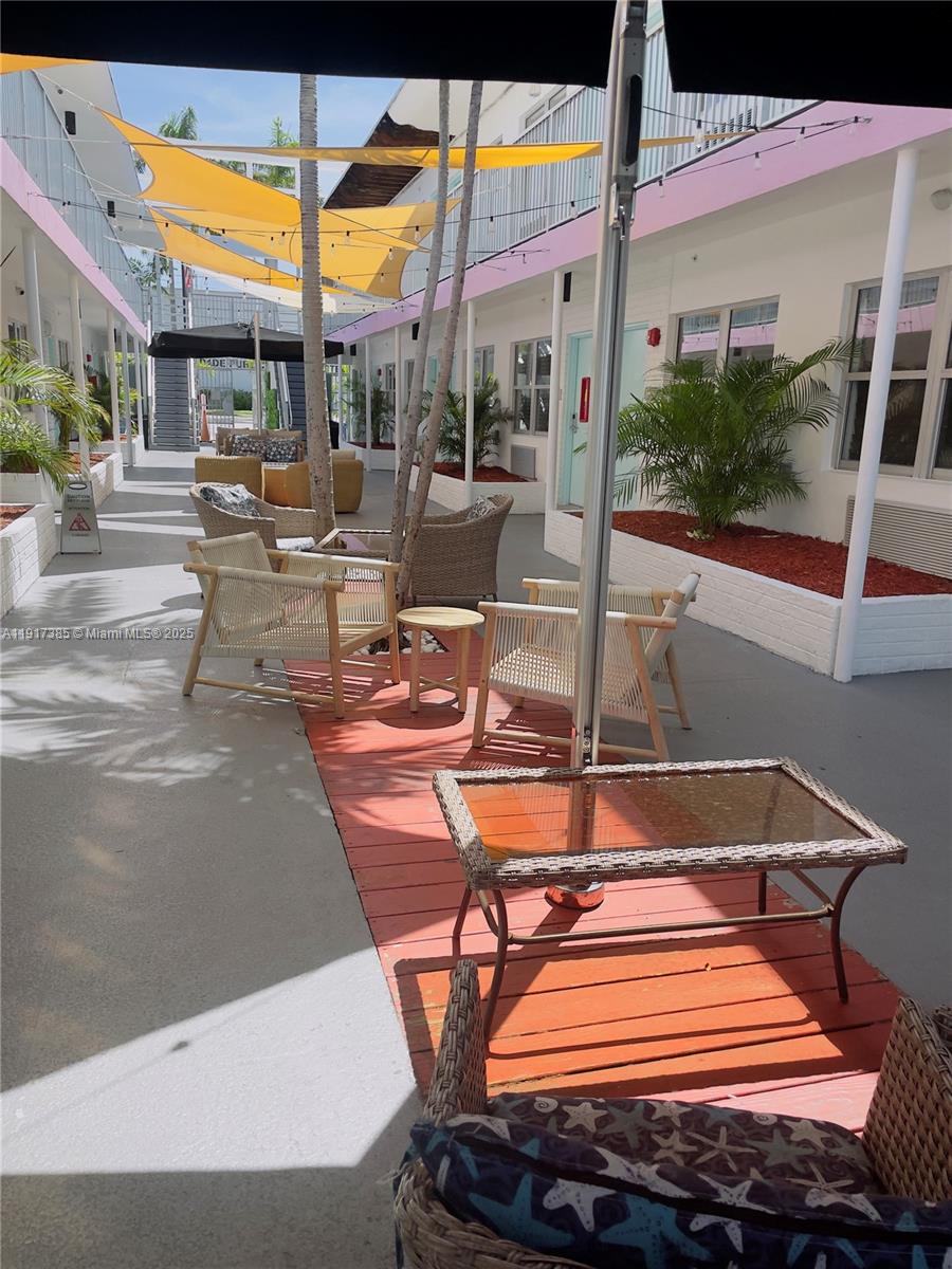 7500 Collins Avenue, Unit 114 Miami Beach, FL 33141 - Photo 9 of 9 a patio with a table and chairs