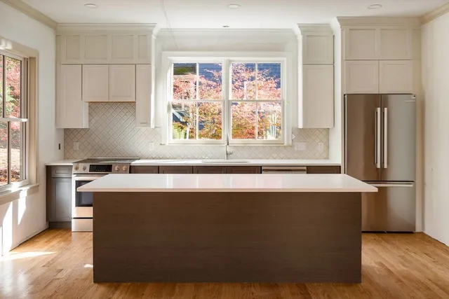 a kitchen with stainless steel appliances granite countertop a refrigerator a sink a stove and a refrigerator