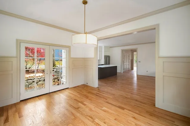 a view of a room with wooden floor a ceiling fan and windows