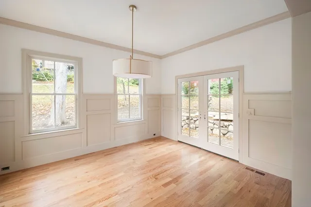 a view of an empty room with window and wooden floor