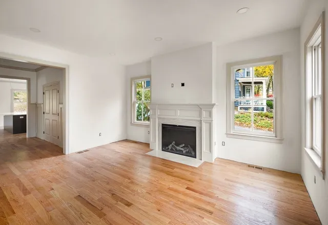 a view of empty room with wooden floor and fireplace
