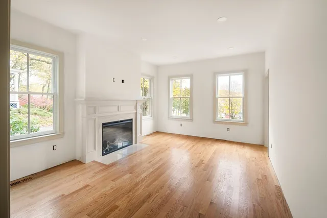 an empty room with windows and fireplace