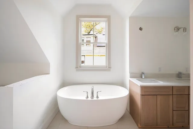 a bathroom with bathtub and window