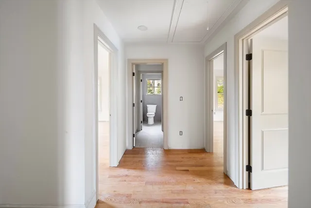 a view of a hallway with wooden floor and closet
