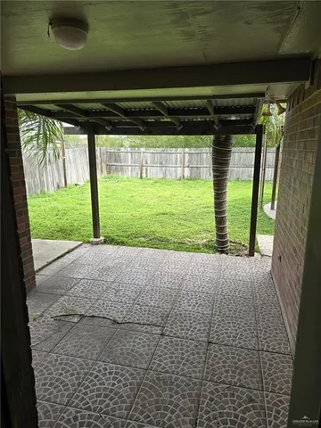 a view of a yard with wooden fence and a large tree