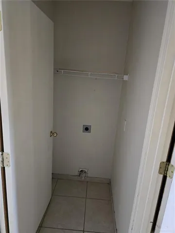 a view of an empty room with a fireplace and a window