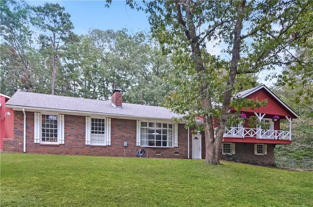 a front view of a house with a garden and trees